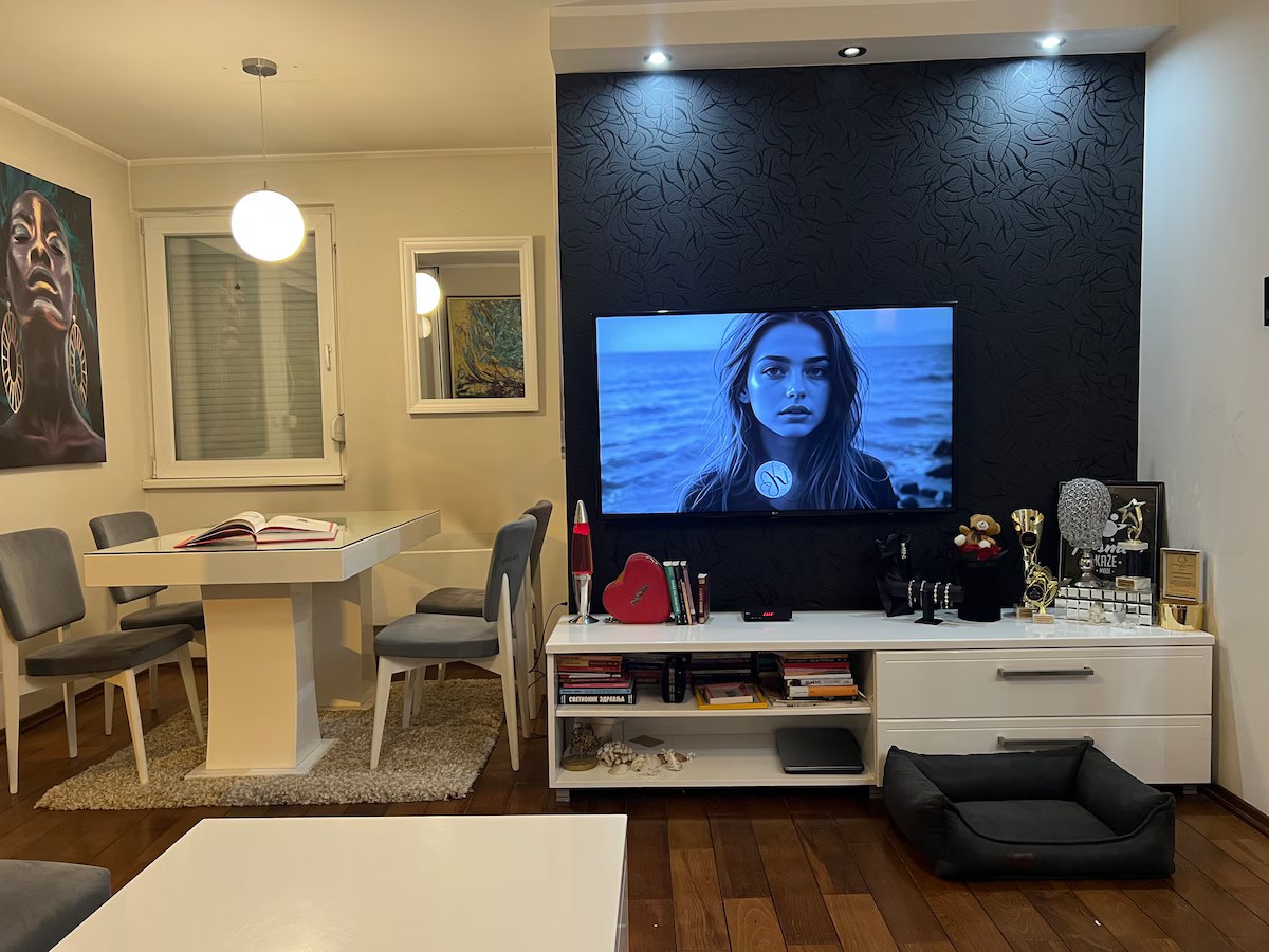 Living area with a large flat-screen TV, media unit and statement art
