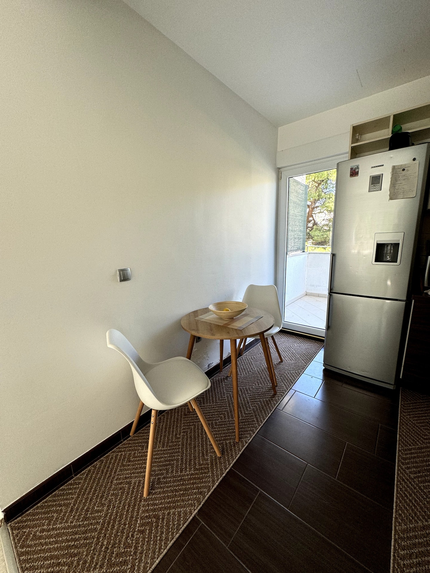 Dining nook with table and chairs beside the balcony door