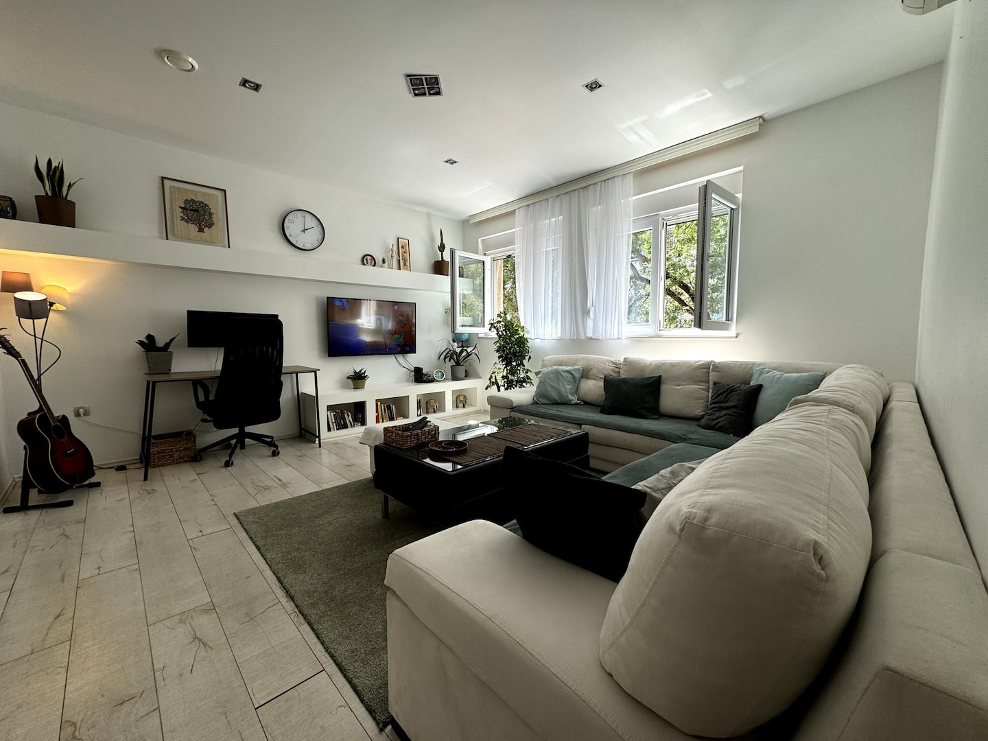 Bright living room with a large sectional sofa and plants
