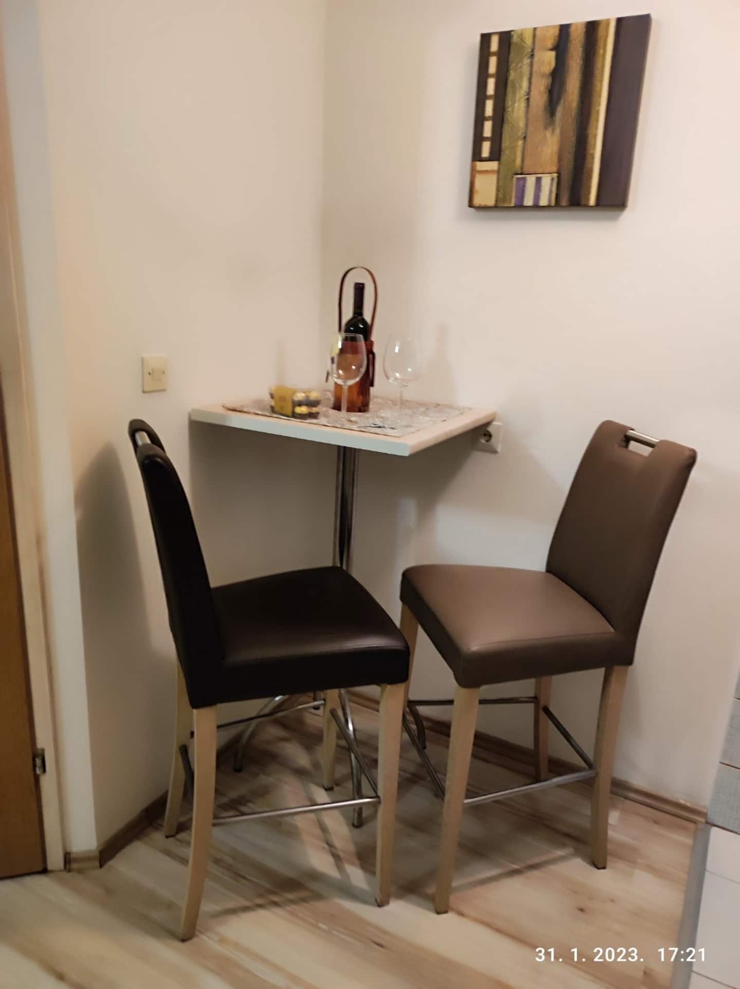 Breakfast bar with two stools and a bottle of wine